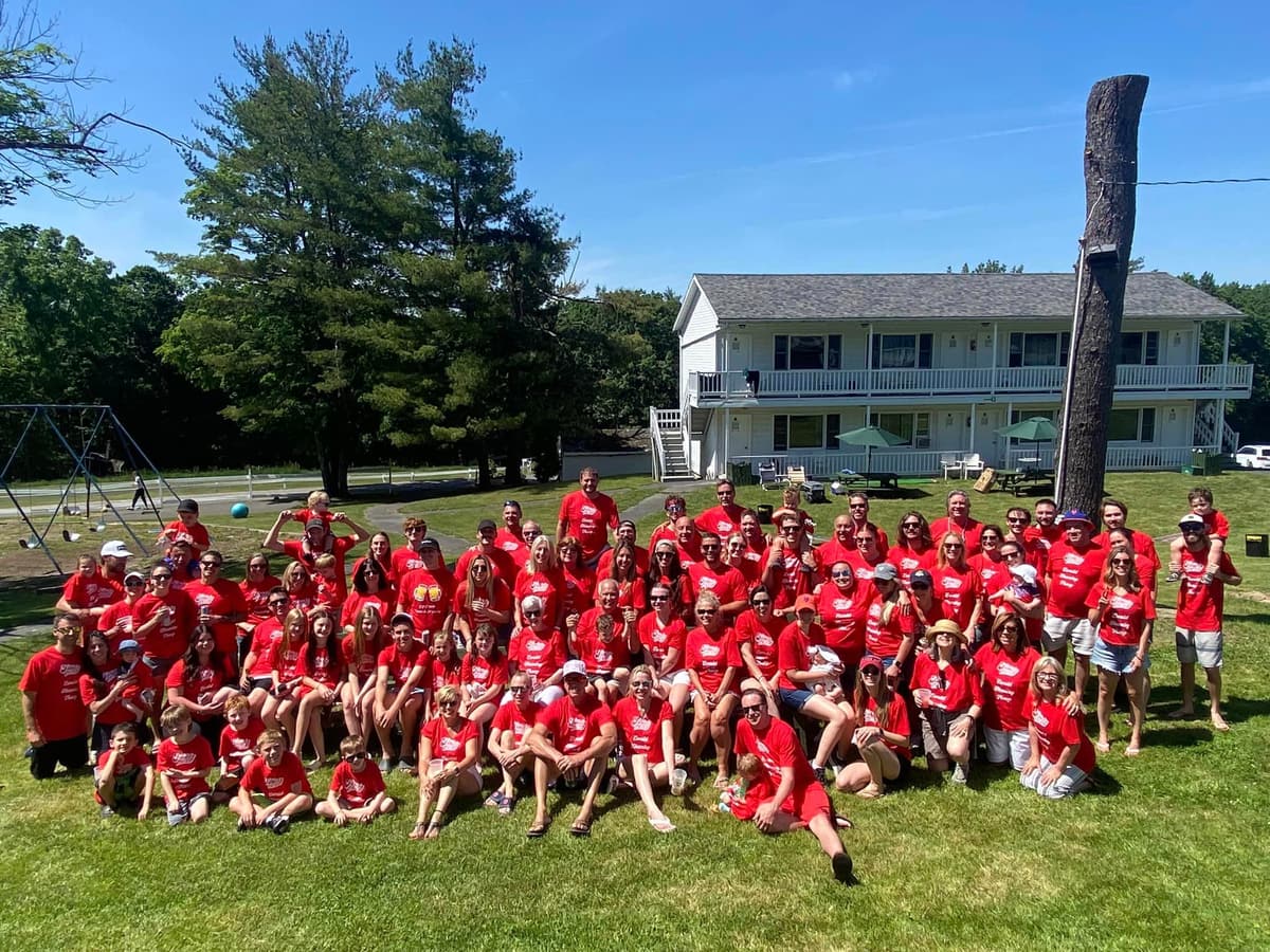 A large family reunion in matching red shirts on the lawn at Gavin's Irish Country Inn, 2024