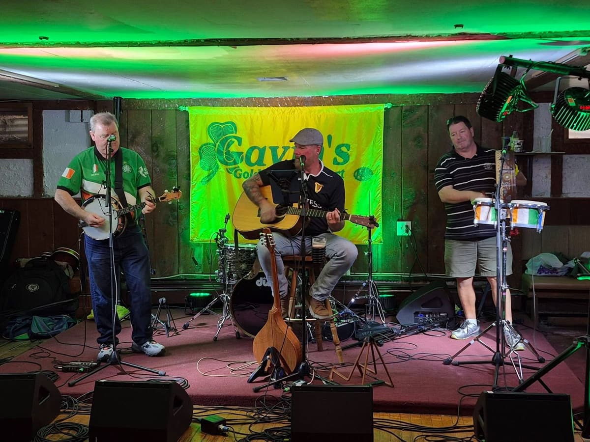 Live Irish band on the stage of Gavin's Pub under green stage lights, East Durham NY